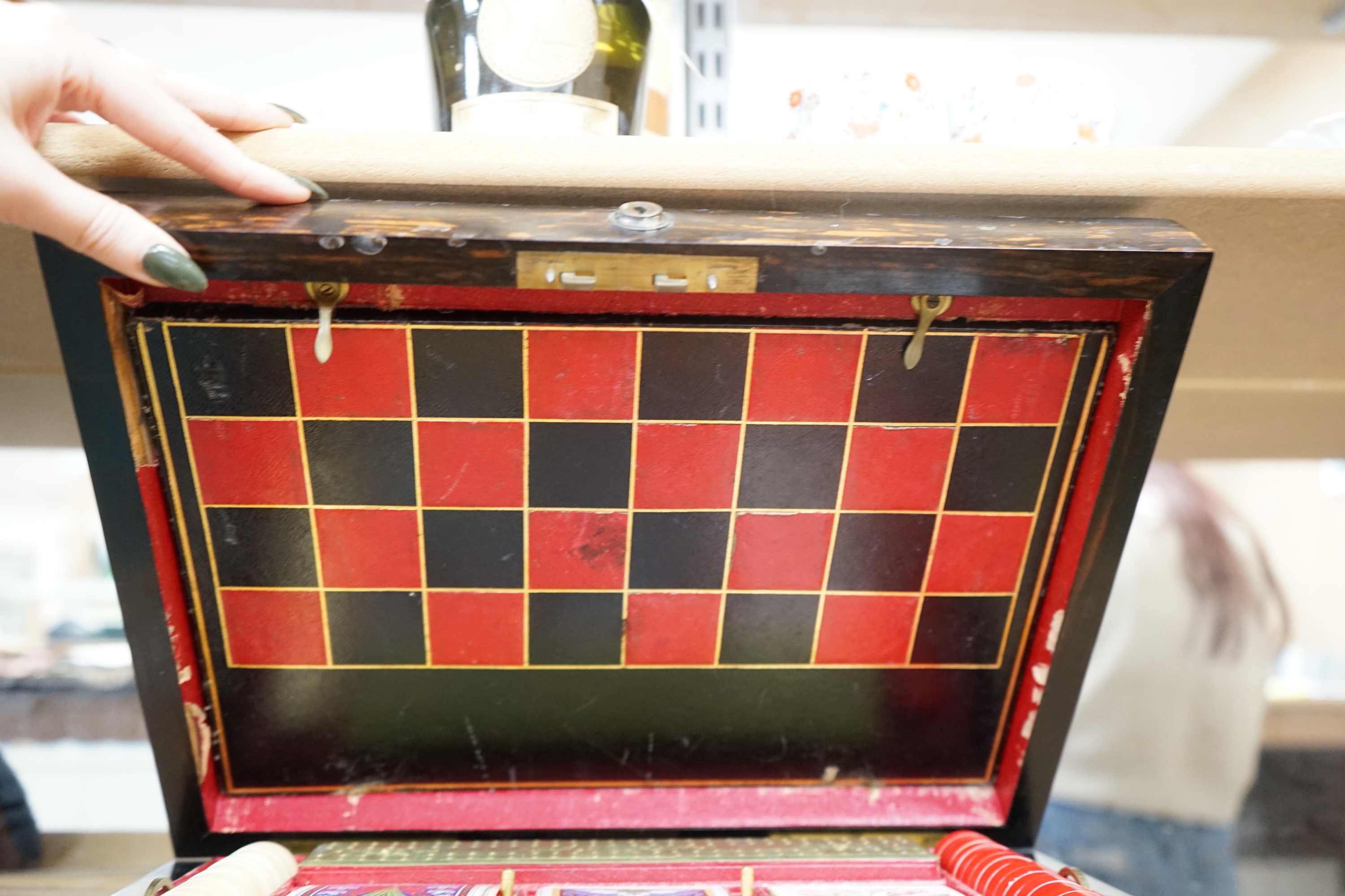 A Victorian coromandel games box with accessories, ivory chess pieces and counters, box 36cm wide x 19cm high. Condition - red interior leather worn and torn in places and box scratched, minor losses to chess pieces. CIT